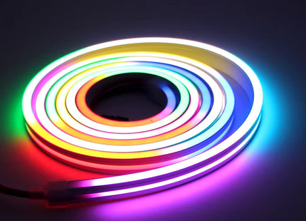 Τυλιγμένος φωτιστικός σωλήνας Neon LED που εμφανίζει πολλαπλά φωτεινά χρώματα σε σκούρο φόντο.